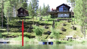 A cabin with a deck overlooking a lake, surrounded by trees. - Nedre Gärdsjö by Interhome (Rättvik)