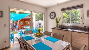 A modern kitchen with a dining area, large windows, and a view of the backyard. - Villa Marie-Jo by Interhome (Prunete)