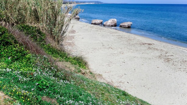 A beach with clear blue water, sandy shore, and some rocks. - Villa Marie-Jo by Interhome (Prunete)