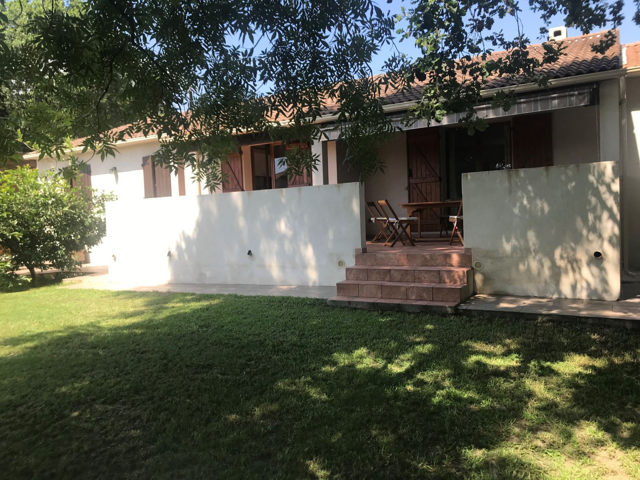 A house with a front porch, steps leading to the entrance, and a small garden area.