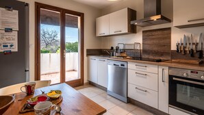 Une cuisine moderne équipée d’un lave-vaisselle, d’un four et d’un porte-couteaux.