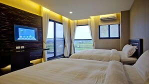 A hotel room with two beds, a TV, and a view of the outdoors. - Wolken Lodge (Pingtung)