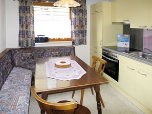 Een koelkast, een oven, kookgerei, borden en bestek
