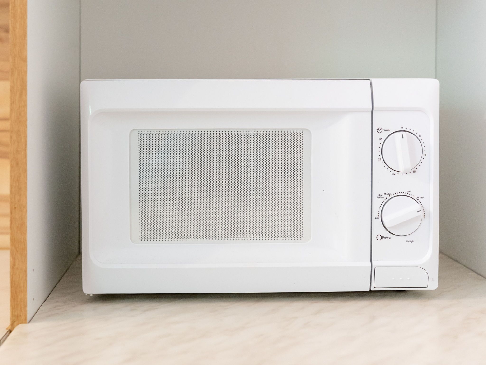 A white microwave oven with two control knobs and a digital display.