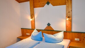 Une chambre à coucher avec une tête de lit en bois, deux tables de chevet et un lit avec une literie bleue.