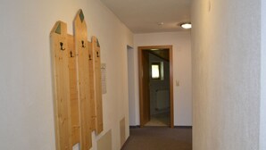Un couloir étroit aux murs décorés de motifs en bois et dont le sol est recouvert d’une moquette.