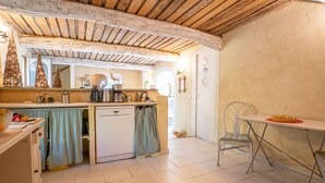 A compact kitchen with a dishwasher, a small table, and a chair. - Le Clermont by Interhome (Chateauneuf de Grasse)