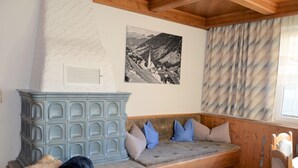 Une pièce chaleureuse avec un banc en bois, une armoire bleue et un tableau représentant un paysage de montagne accroché au mur.