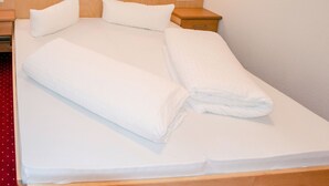 A neatly made bed with white linens and pillows, wooden headboard, and bedside tables with lamps. - Apartment Jäger by Interhome (Kappl)