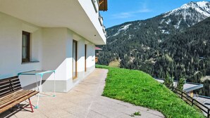 Un bâtiment doté d’un patio, d’un banc et d’une table.