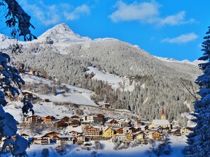 A snow-covered mountain town with wooden buildings, a church, and a ski lift. - Hedwig Jäger by Interhome (Kappl)