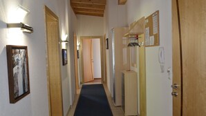 A hallway with wooden doors, a blue carpet, and a wooden ceiling. - Apart Garni Wachter by Interhome (Kappl)