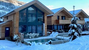 Eine moderne Lodge mit Glasfassade, Holzaußenbau und einem Poolbereich.