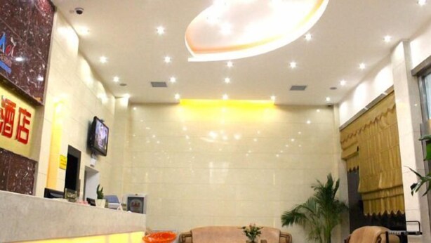 A hotel lobby with a reception desk, a sofa, and a coffee table. - Wo'ermei Hotel (Enshi City)
