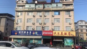 A multi-story building with several commercial establishments on the ground floor. - Wo'ermei Hotel (Enshi City)