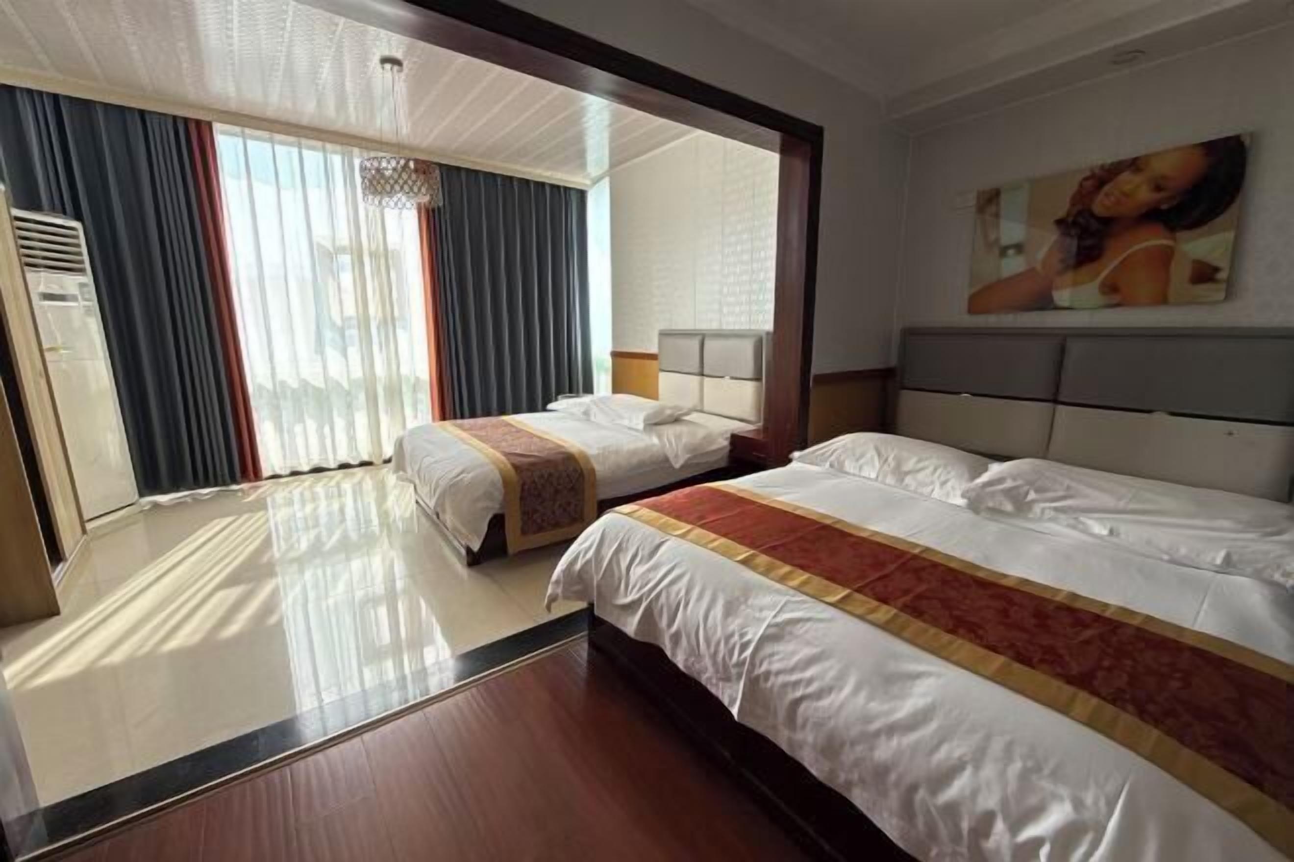 Habitación de hotel con dos camas, un espejo grande, un cuadro en la pared y vistas al exterior.