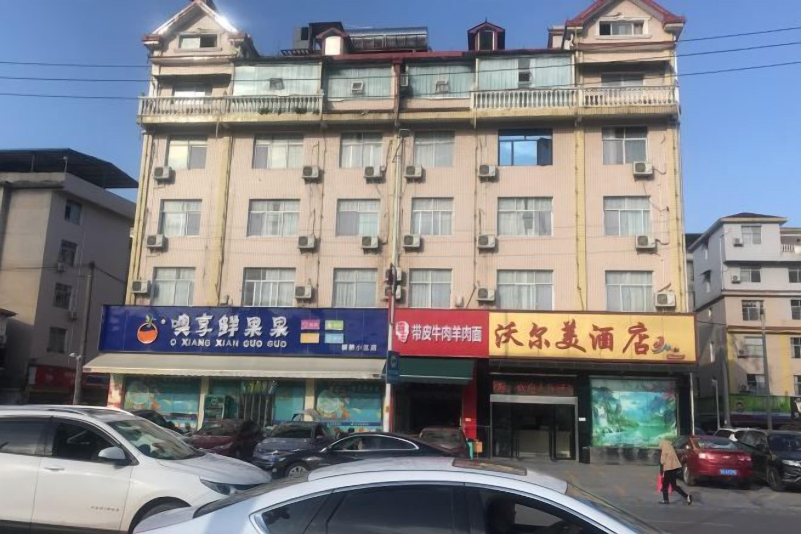 A multi-story building with commercial establishments on the ground floor, including a restaurant and a convenience store.