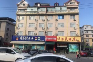 Un edificio de varios pisos con locales comerciales en la planta baja, incluyendo un restaurante y una tienda de conveniencia.