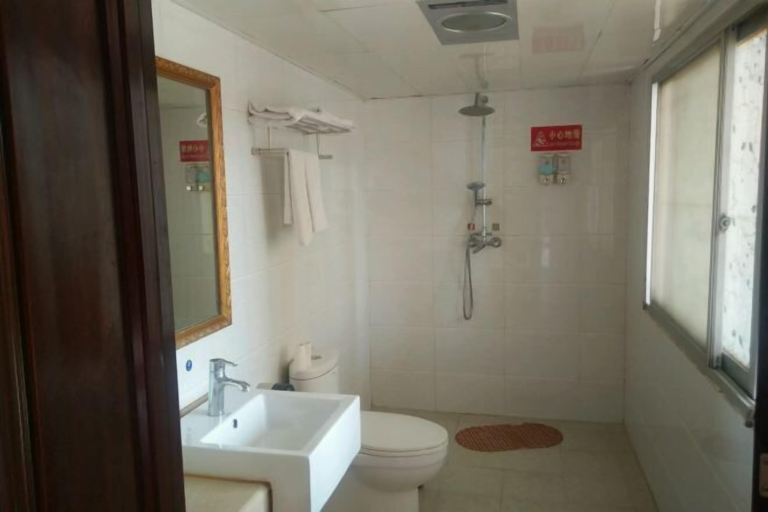 Ein kleines Badezimmer mit Waschbecken, Toilette und Dusche.