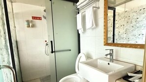 A bathroom with a shower, toilet, sink, and a mirror with a floral pattern. - Wo'ermei Hotel (Enshi City)
