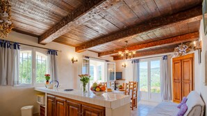 A spacious kitchen with wooden cabinets, a dining area with a table and chairs, and a cozy seating area with a sofa.
