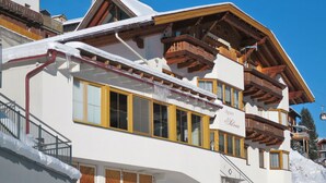 A multi-story hotel with a traditional Alpine architectural style, featuring wooden balconies and large windows. - Apartment Silvia by Interhome (Kappl)