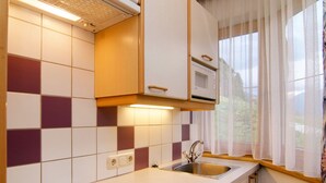 A kitchen with a gas stove, a microwave, and a sink. - Apartment Silvia by Interhome (Kappl)
