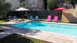 A rectangular swimming pool with a tiled deck, surrounded by a low brick wall. - Vacation home Kasara by Interhome (Mazan)