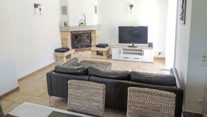 A living room with a fireplace, a TV, and a sofa. - Vacation home Kasara by Interhome (Mazan)