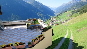 A terrace with a checkered floor, outdoor seating, and potted plants. - Bergblick by Interhome (Kappl)