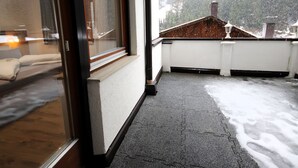 A balcony with a view of a snowy landscape and a building with a brown roof. - The Siegele by Interhome (Kappl)
