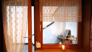 A wooden bench with a lantern, a window with lace curtains, and a door with a brass handle. - The Siegele by Interhome (Kappl)