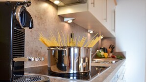 A kitchen with a modern stove, a pot of spaghetti, and a coffee machine. - Wechner by Interhome (Kappl)