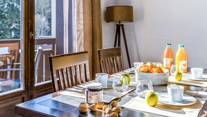 A breakfast table with pastries, fruits, and juice bottles.