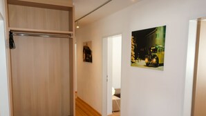 Ein Flur mit Holzboden, einem Holzschrank und einem gerahmten Bild an der Wand.