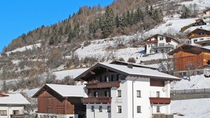 A multi-story building with a balcony, surrounded by snow-covered terrain and trees. - Alpenherz by Interhome (Prutz/Kaunertal)