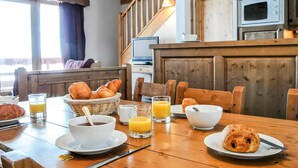 A breakfast setting with bread, coffee, and orange juice on a wooden table. - Les Hauts de Comborciere by Interhome (La Toussuire)
