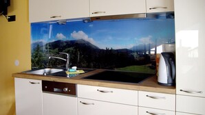 A kitchen with a sink, a coffee maker, and a cabinet with a window above the sink. - Apart Grazia by Interhome (Prutz/Kaunertal)