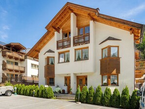 Un hôtel à plusieurs étages doté de balcons en bois et d’un espace de stationnement.