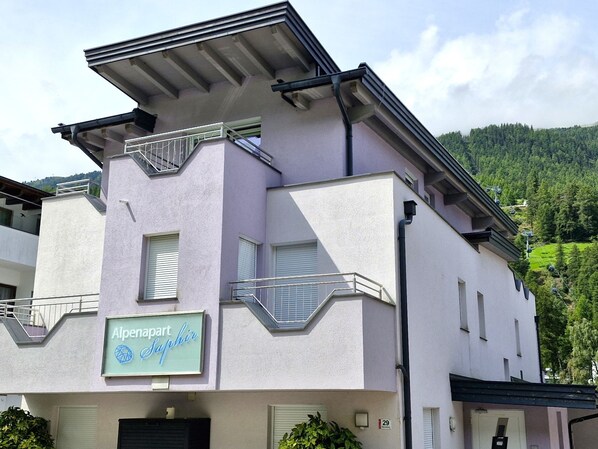 A multi-story building with a sign reading "Alpenapart Saphir".