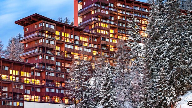 A multi-story hotel with balconies and large windows, surrounded by snow-covered trees. - Le Roc Belle Face by Interhome (Bourg St Maurice)