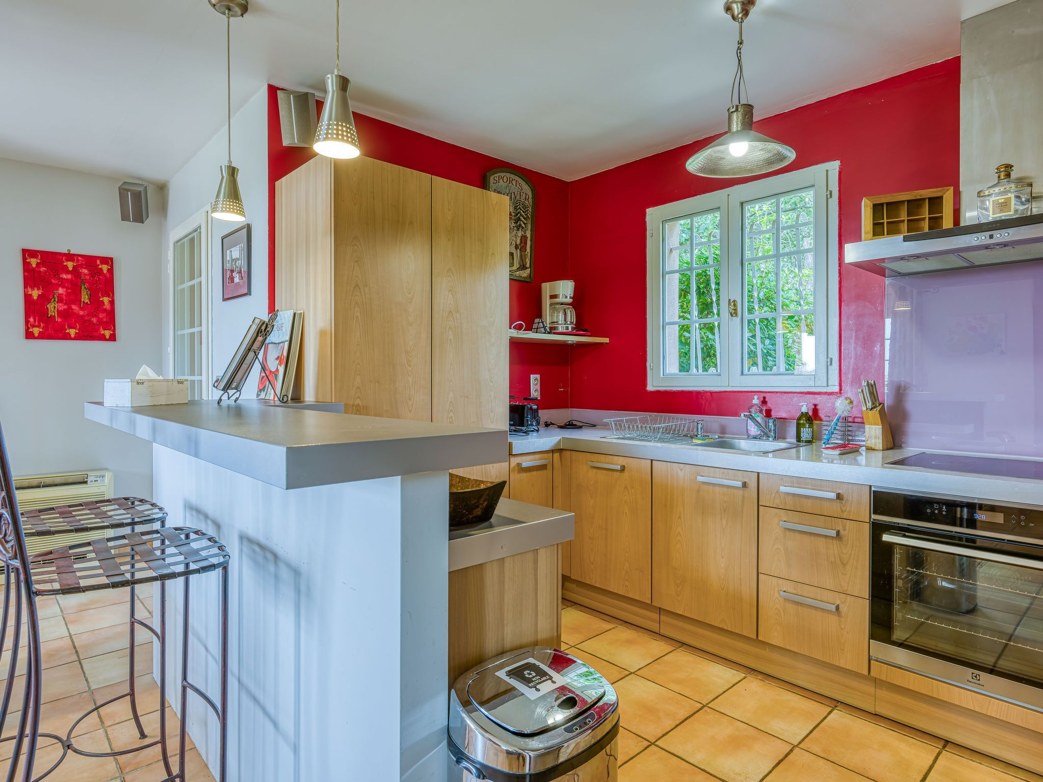 Une cuisine moderne avec des meubles en bois, un évier en acier inoxydable et un four encastré.