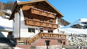 Un immeuble en bois à plusieurs étages, doté de balcons, d’un escalier et d’une enseigne indiquant qu’il s’agit d’un hôtel.