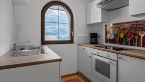 Een moderne keuken met een groot raam, een ingebouwde oven en een koffiezetapparaat.