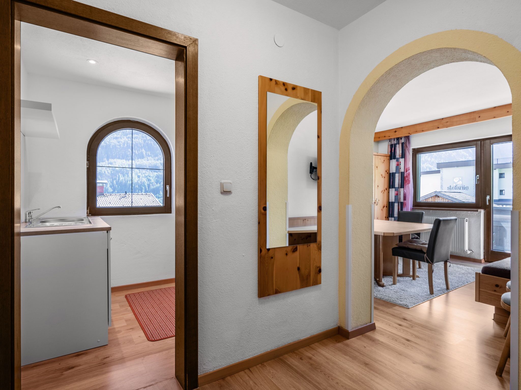 Une cuisine moderne avec une fenêtre, un coin repas comprenant une table et des chaises, et une vue sur l’extérieur.