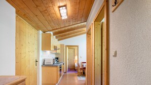 A wooden interior with a kitchen area, wooden flooring, and a visible door leading to another room. - Apartment Nadine by Interhome (Sölden)