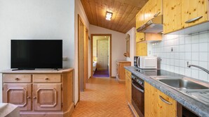 A modern kitchen with wooden cabinets, a built-in oven, a microwave, and a large sink. - Apartment Nadine by Interhome (Sölden)