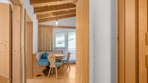 Un interior de madera con zona de comedor, un banco y una mesa con sillas.