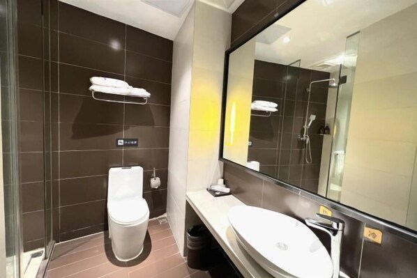 A modern bathroom with a toilet, sink, and a large mirror. - XiYueli Hotel(Guiping Xishan store) (Guiping)