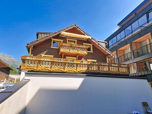 A wooden chalet with a balcony, a modern building adjacent to it, and a mountain in the background. - Elisabeth by Interhome (Sölden)